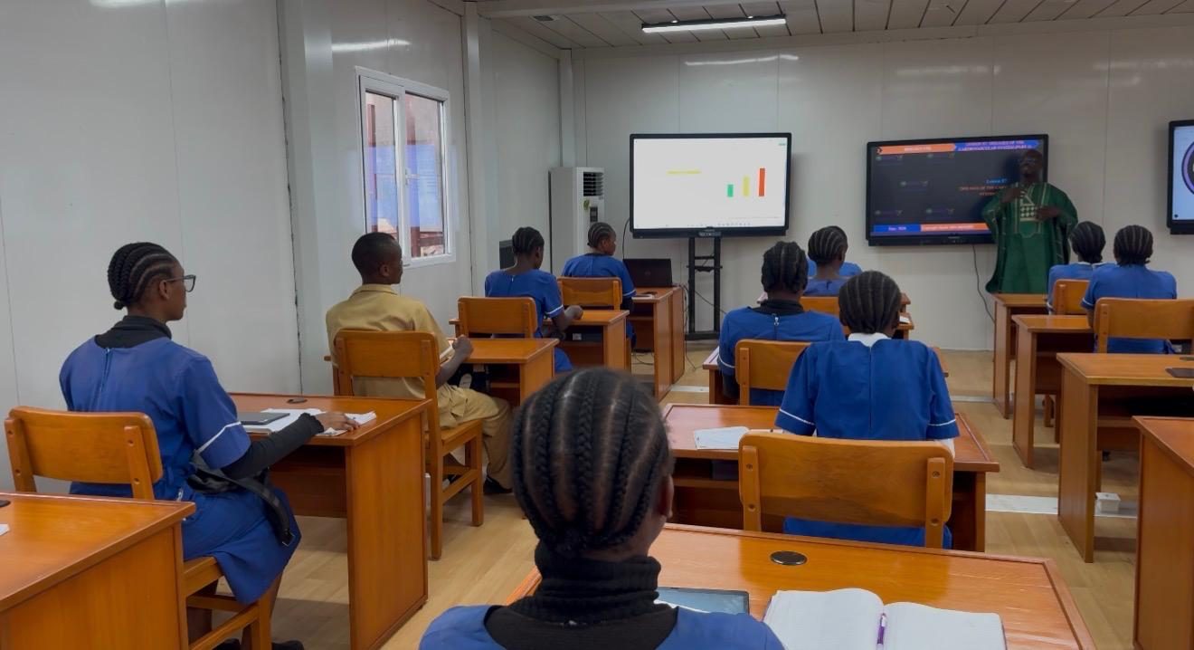 A teacher teaching a class of students using a simulation in the intelligent classroom.